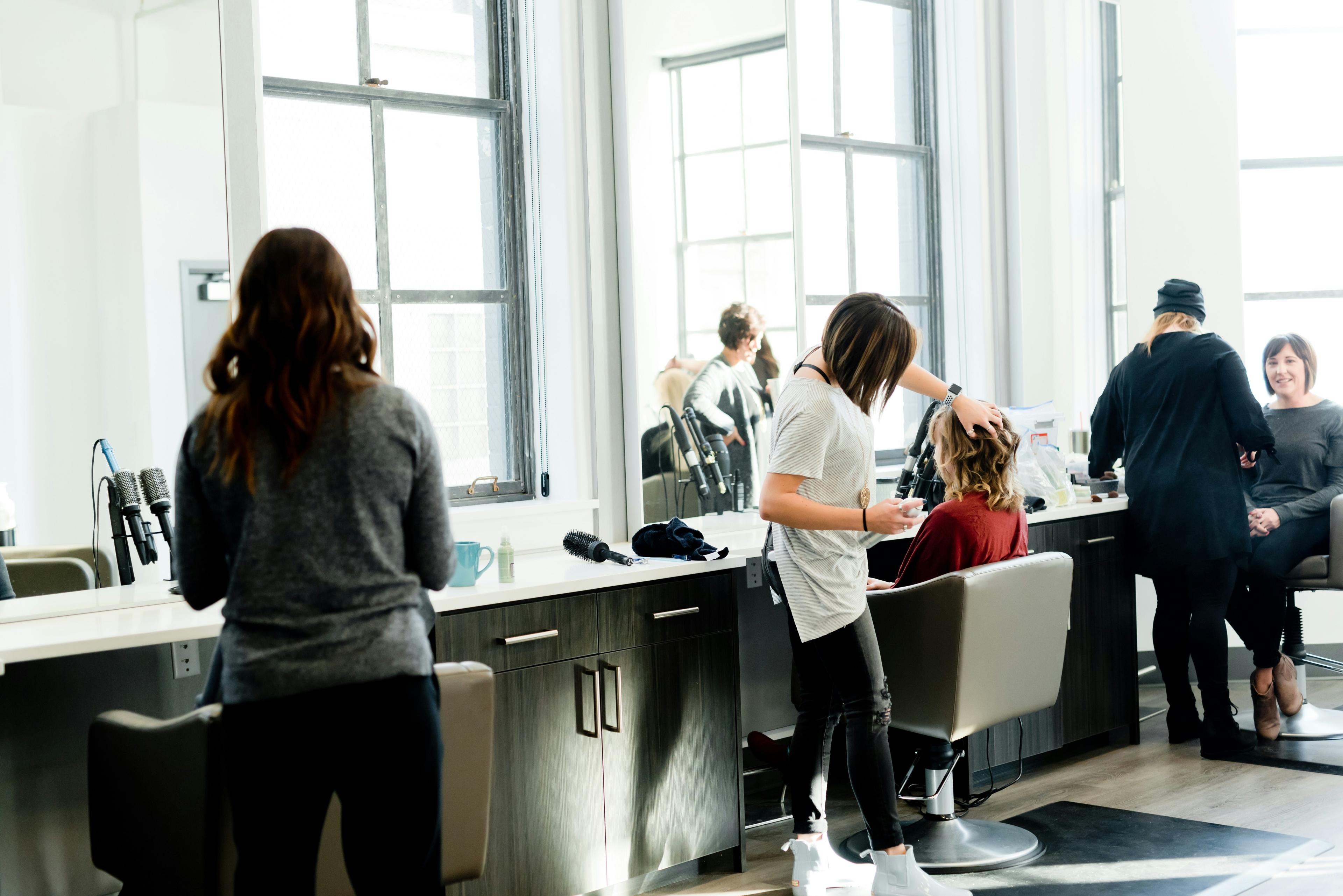 Hairstylist cutting and styling a client's hair in a modern salon