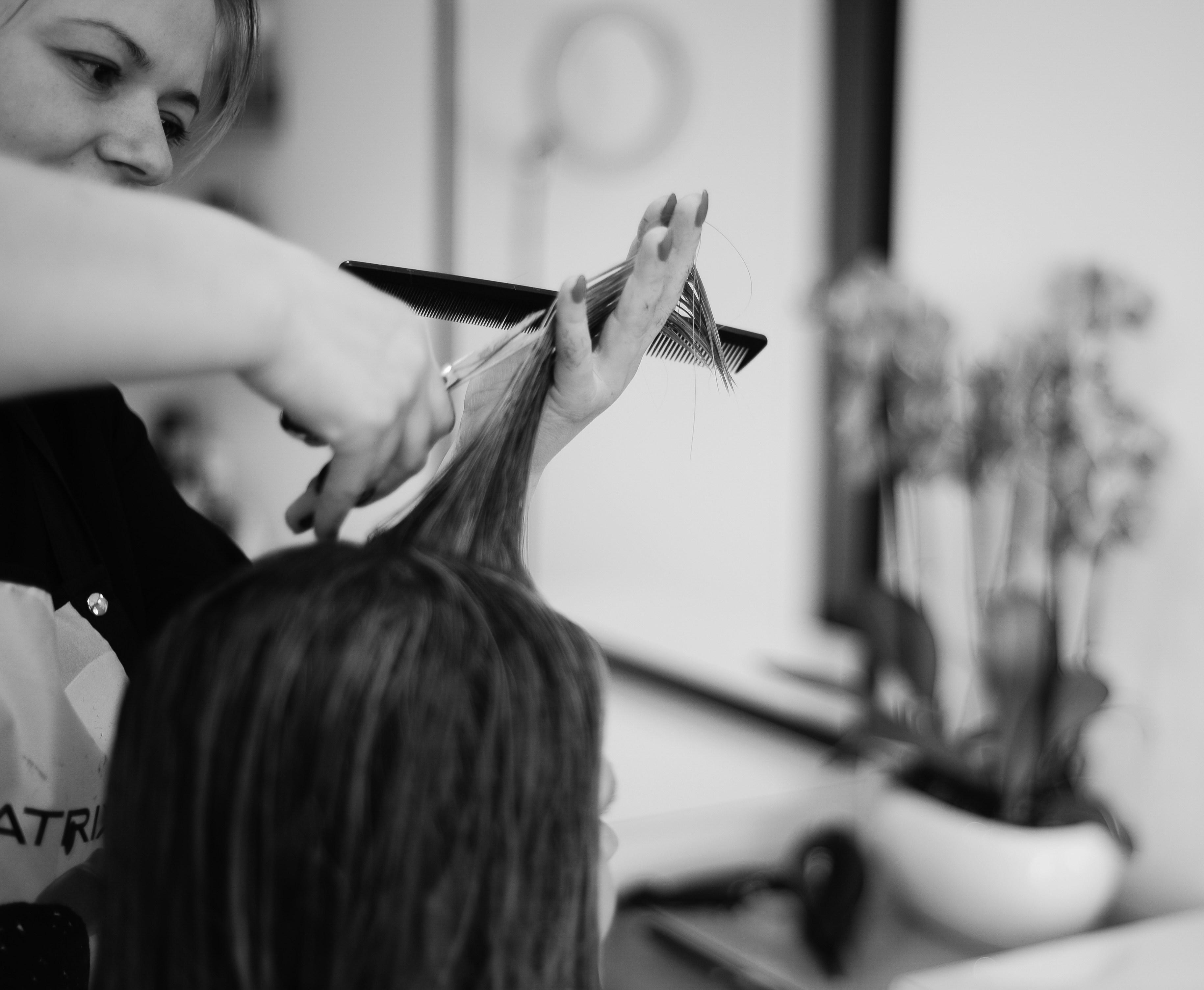 Hairstylist cutting and styling hair in a modern salon