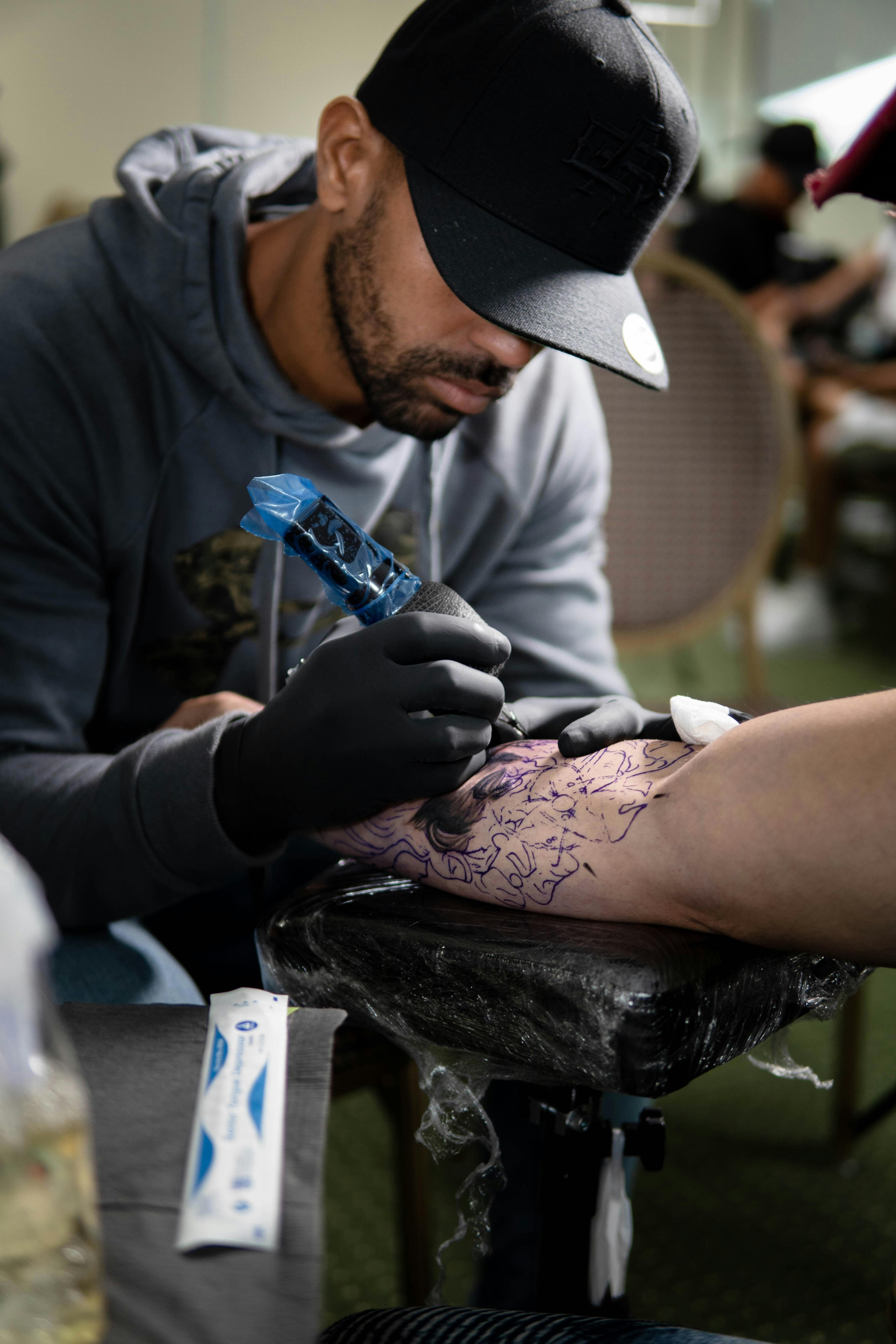 Tattoo artist carefully inking a detailed design on a client's arm